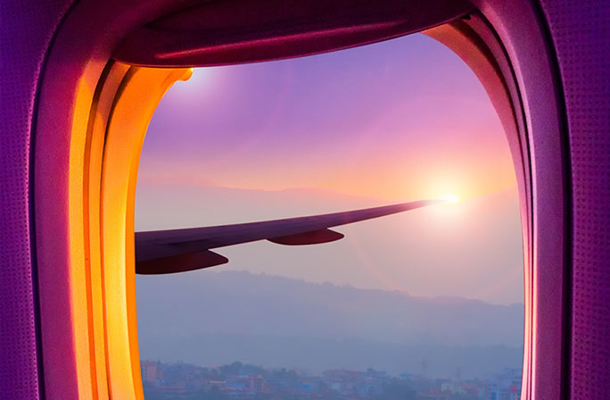 View through an airplane window at sunset